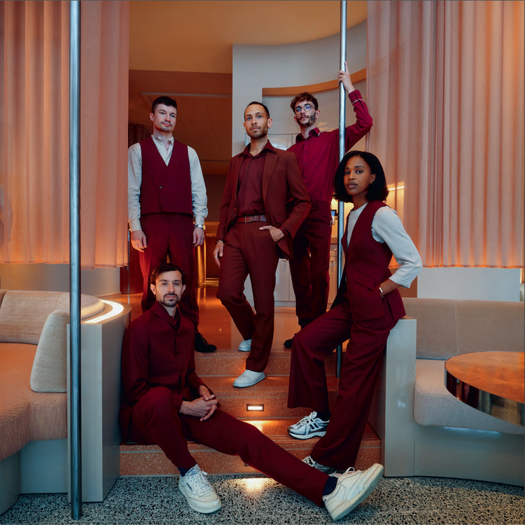 Group of people in matching maroon Gresham Blake uniforms in a modern hotel interior setting
